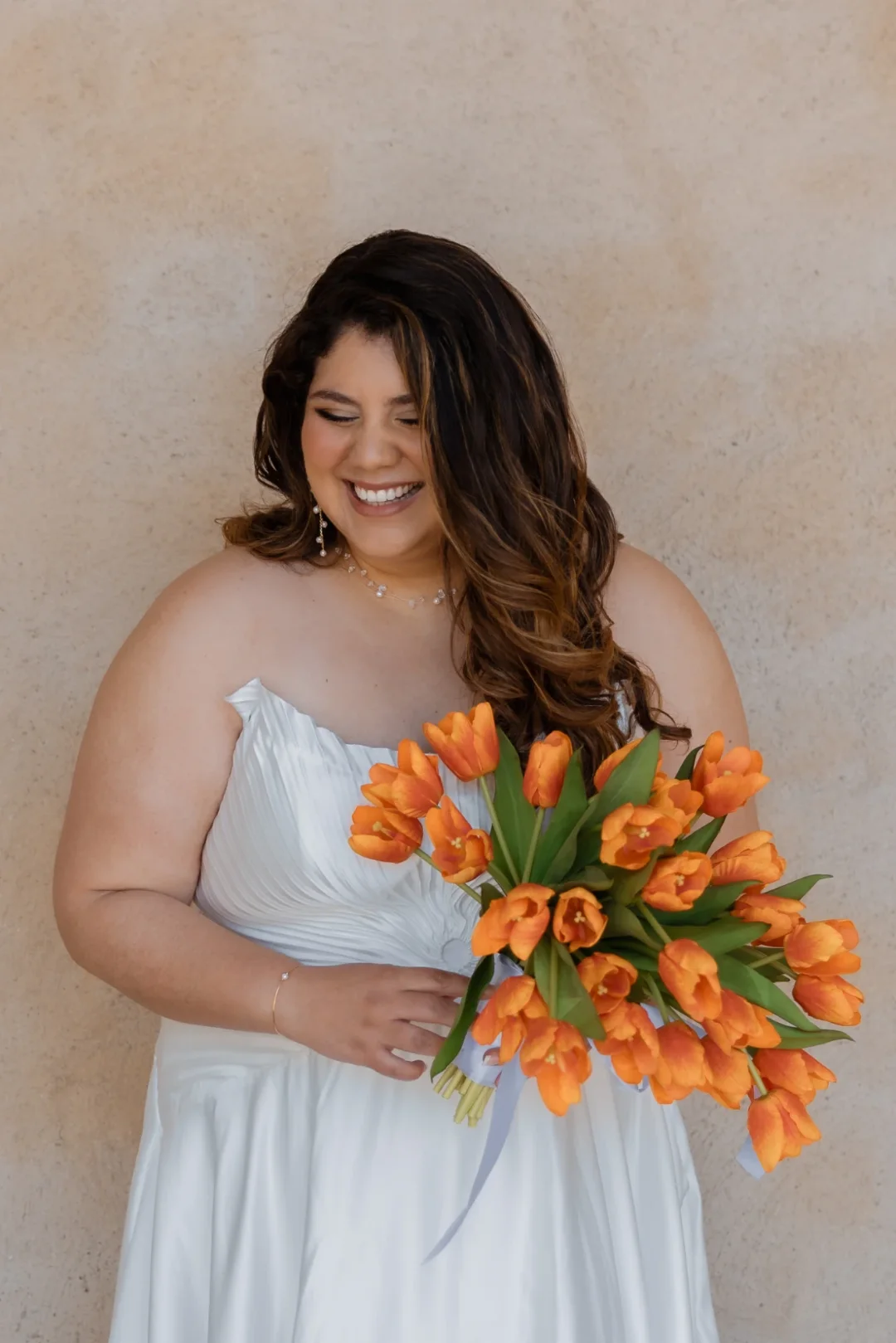 Laughing bride with a bouquet of orange tulips