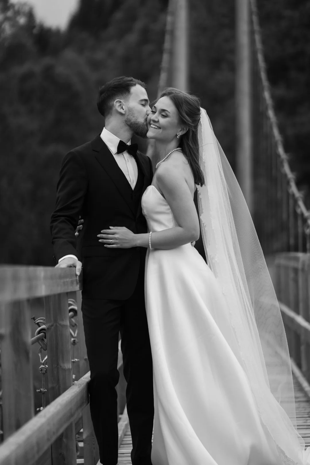 A bride and groom on a bridge, black and white