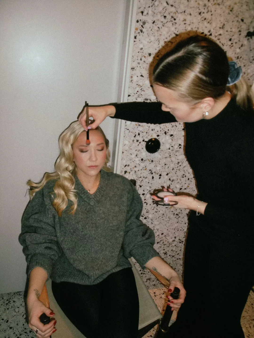 Lovina doing a client's makeup in the studio